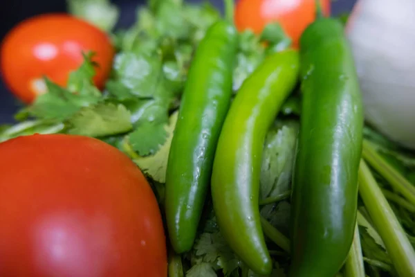 Chili paprika 's, ui en een tomaat boven koriander — Stockfoto