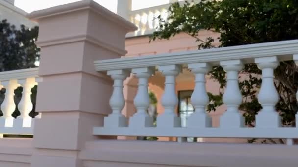 Vista lisa do belo edifício pastel-rosa e branco — Vídeo de Stock