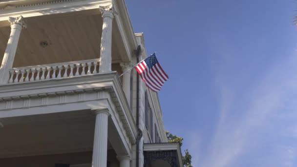 Mavi gökyüzünün altındaki balkonda asılı eski Amerikan bayrağı — Stok video