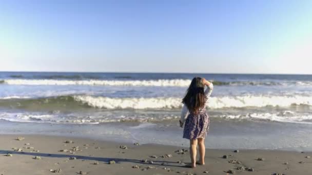 Adorable niña en la playa con hermoso mar y cielo como fondo — Vídeo de stock