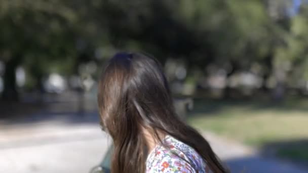 Очаровательная молодая девушка чистит голову детской статуе в парке — стоковое видео