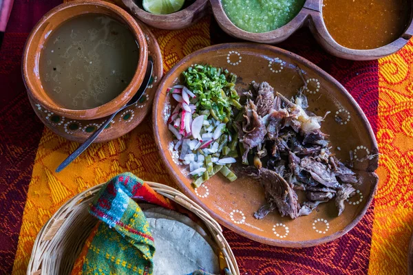 Mexican chopped lamb meat, hot sauces, and tortillas on colorful tablecloth — Stock Photo, Image