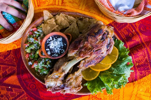 Roasted meat with vegetables and refried beans on colorful tablecloth — Stock Photo, Image