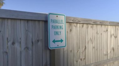 Paralel park yeri sadece arka planda mavi gökyüzü olan ahşap çitte.