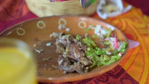 Mexican chopped lamb meat and sliced nopales above colorful tablecloth — Stock Video