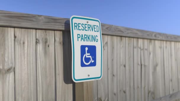 Rezervované parkovací znak na dřevěném plotě s modrým nebem jako pozadí — Stock video
