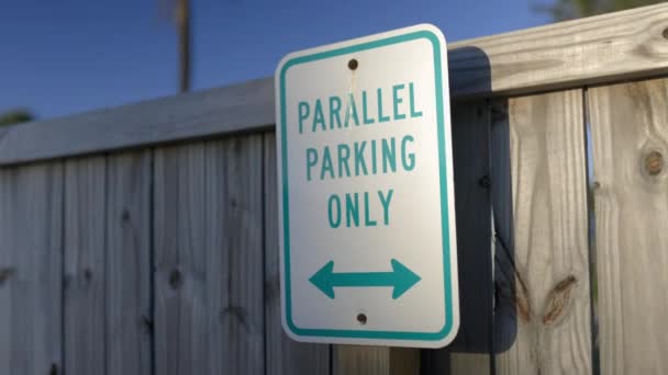 Równolegle parking tylko znak na drewnianym ogrodzeniu z niebieskim niebem jako tło — Wideo stockowe