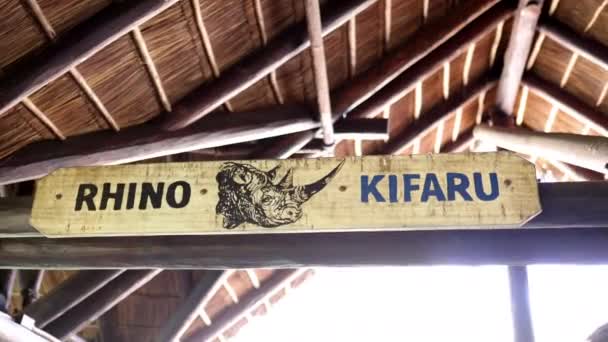 Imagen de aspecto vintage de un rinoceronte sobre un largo cartel de madera bajo el techo — Vídeo de stock