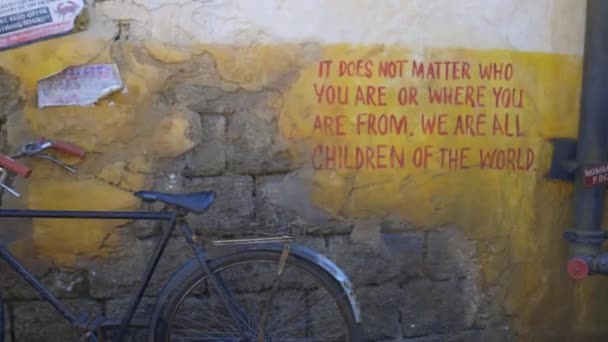 Vue en douceur du vélo garé à côté des murs rustiques avec message écrit — Video