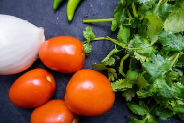 Biber, soğan ve kişniş üzerine domates.