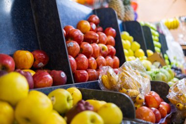 Elmalar, küçük muzlar ve daha fazlası olan renkli meyve standlarının yakın çekimi