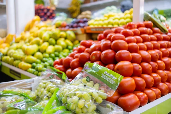 Renkli sebze ve meyve standı, domates, üzüm, mango ve daha fazlası.