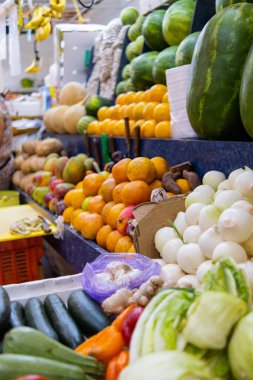 Renkli meyve ve sebzeler karpuz, portakal, soğan ve daha fazlası ile dururlar.