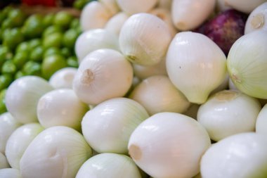 Arka planda bulanık yeşil domatesli soğan yığını