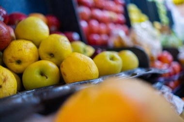 Elmalar, küçük muzlar ve daha fazlası olan renkli meyve standlarının yakın çekimi