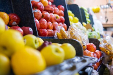 Elmalar, küçük muzlar ve daha fazlası olan renkli meyve standlarının yakın çekimi