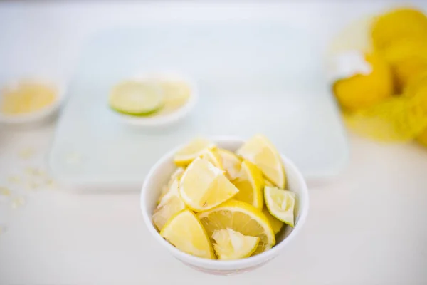 Fette di lime e limone in una piccola ciotola con sfondo sfocato — Foto Stock