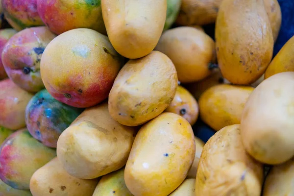 Close-up van kleurrijke fruitkraam met stapels mango 's — Stockfoto