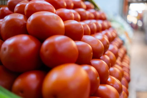 Stapel tomaten op statief met meer groenten als achtergrond — Stockfoto