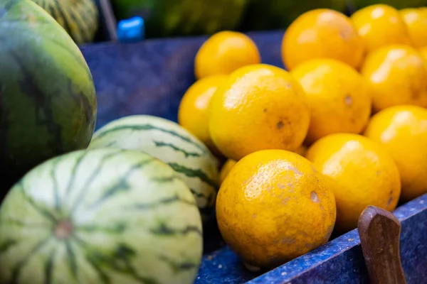 Close-up van kleurrijke fruitkraam met watermeloenen en sinaasappels — Stockfoto