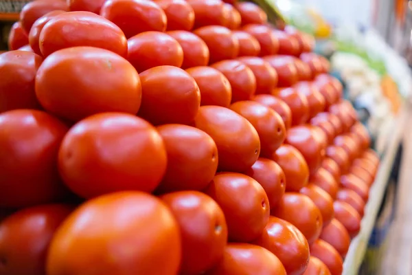 Stapel tomaten op statief met meer groenten als achtergrond — Stockfoto