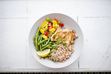 Yeşil fasulye ve dolma biberli tavuk ve karabuğday tabağı.