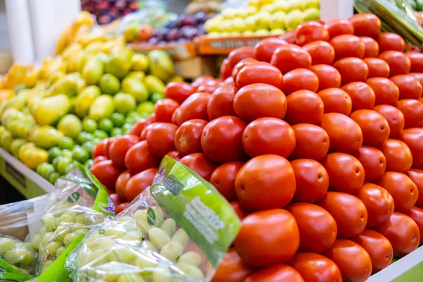 Banco di verdure e frutta colorato con pomodori, uva, manghi e altro ancora — Foto Stock