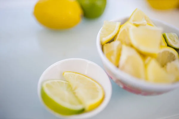 Чашки лимонных ломтиков и фрукты на столе — стоковое фото