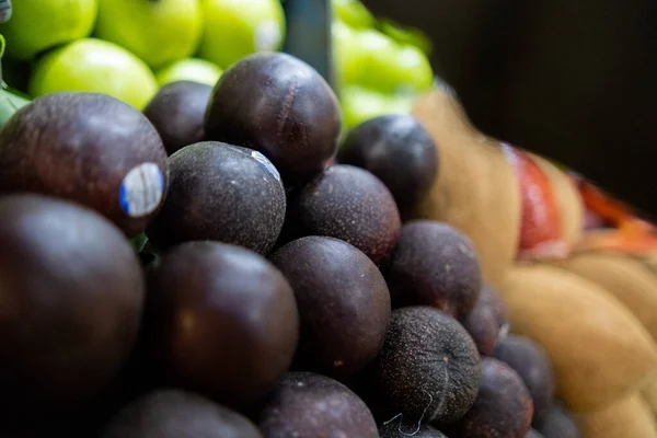 Close-up van kleurrijke fruitkraam met pruimen, mamey, en appels — Stockfoto