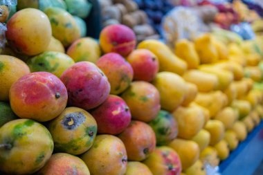 Taze mangolu renkli bir meyve standının yakın çekimi.