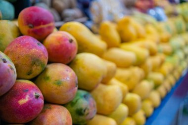 Taze mangolu renkli bir meyve standının yakın çekimi.