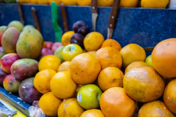 Close-up af farverige frugtstativ med appelsiner og mango - Stock-foto