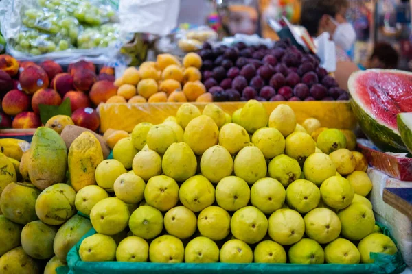 Farverig frugt står med guavabær, mango, ferskner og meget mere - Stock-foto