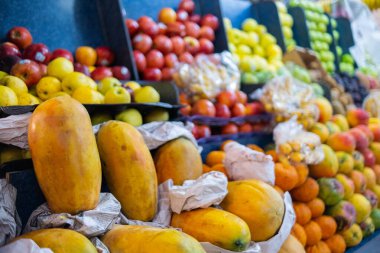 Papayalar, kırmızı ve sarı elmalar ve daha fazlası ile renkli meyve standı