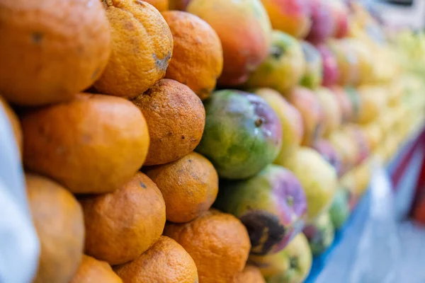 Close-up af en farverig frugtbod med mandariner og mango - Stock-foto