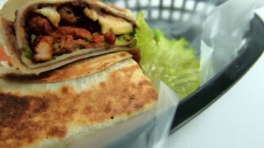 Plastik sepette baharatlı domuz burrito ve marul.