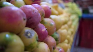 Taze mangolu renkli bir meyve standının yakın çekimi.