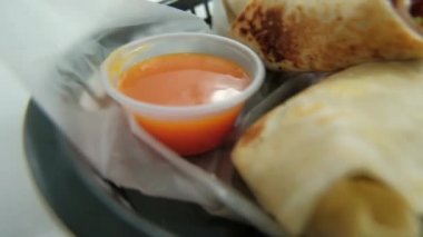 Plastik sepette baharatlı domuz burrito ve marul.