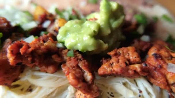 Adding green sauce on top of spicy meat, refried beans and cheese — Stock Video