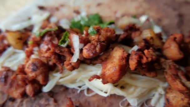 Adicionando coentro e cebola em cima de carne picante, feijão frito e queijo — Vídeo de Stock