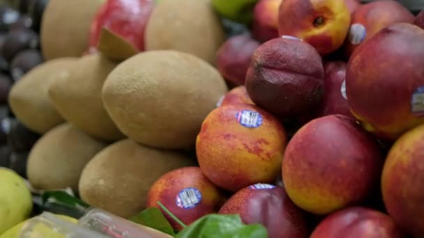 Kolorowe stoisko owocowe z mamusią, brzoskwiniami, mango i więcej — Wideo stockowe