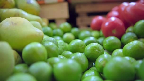 Mangolu, limonlu ve domatesli meyve ve sebze standının yakın çekimi. — Stok video