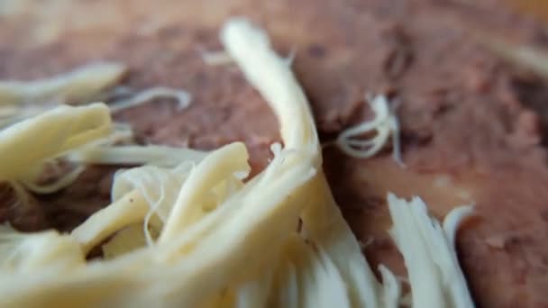 Feijão frito espalhado com queijo Oaxaca em cima — Vídeo de Stock