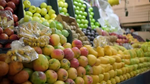 Colorful fruit stand with tangerines, apples, mangoes, bananas, and more — Stock Video