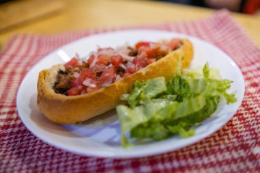 Beyaz ve kırmızı kareli peçetenin üzerindeki bir tabakta Meksika yumuşağı ve marul.