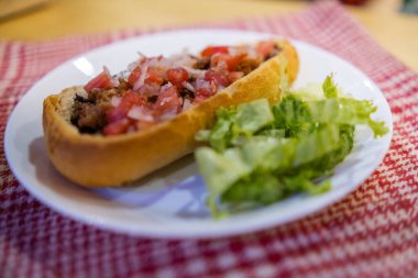 Beyaz ve kırmızı kareli peçetenin üzerindeki bir tabakta Meksika yumuşağı ve marul.