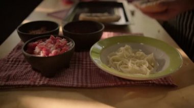 Siyah kase pico de gallo ve kareli masa örtüsünün üstünde bir tabak peynir.