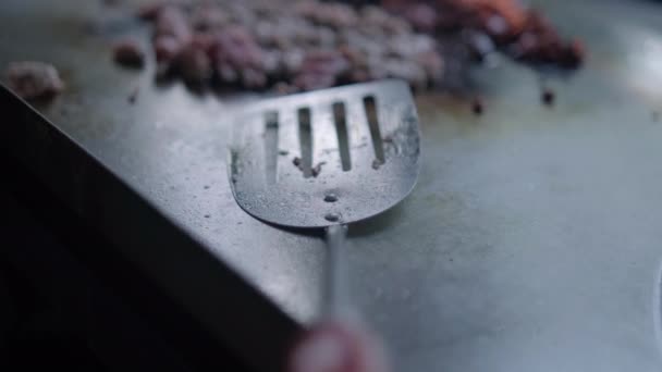 Spatula and chopped Mexican-style meat on a griddle — Stock Video