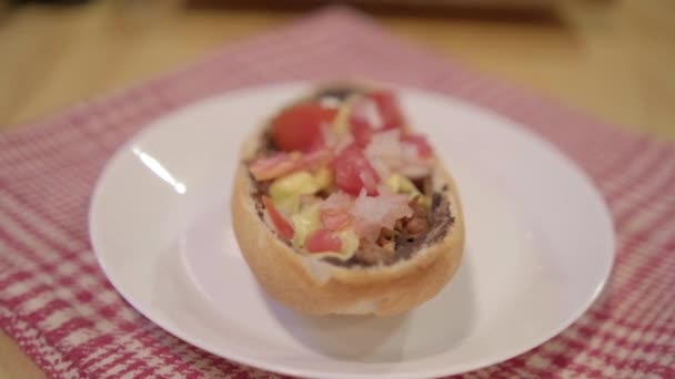 Traditional Mexican mollete on a plate above white and red checkered napkin — Stock Video