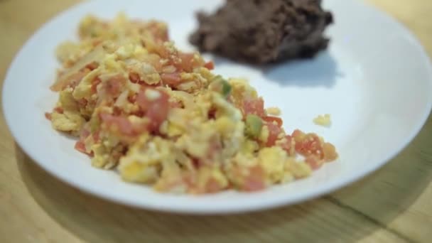 Ovos de estilo mexicano e feijão refrito em um prato branco — Vídeo de Stock